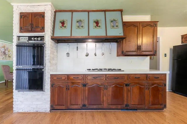 a kitchen with granite countertop a stove and cabinets