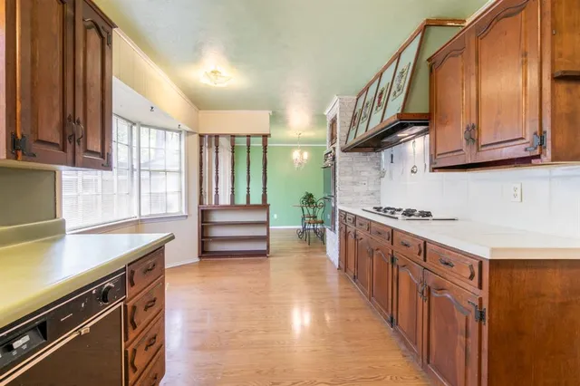 a kitchen with stainless steel appliances a sink stove and cabinets