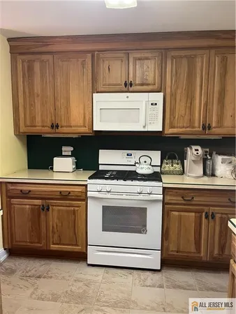 a kitchen with granite countertop a sink stove and cabinets