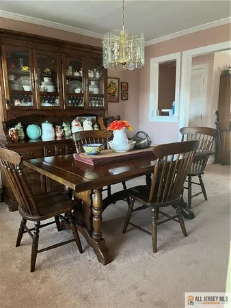 a dining room with furniture a chandelier and window