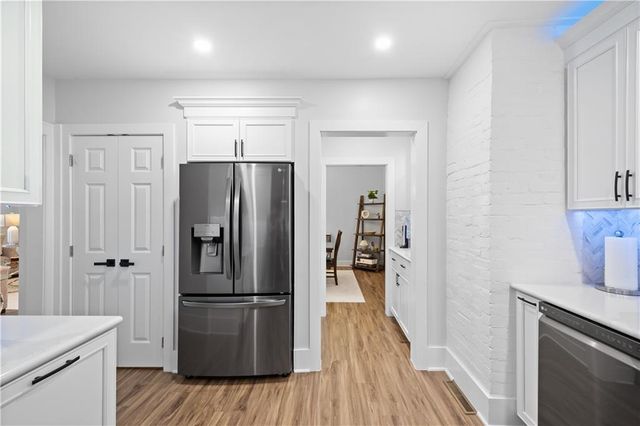 a kitchen with a refrigerator and wooden floor