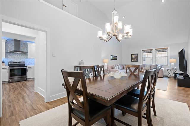 a view of a dining room with furniture a chandelier and wooden floor