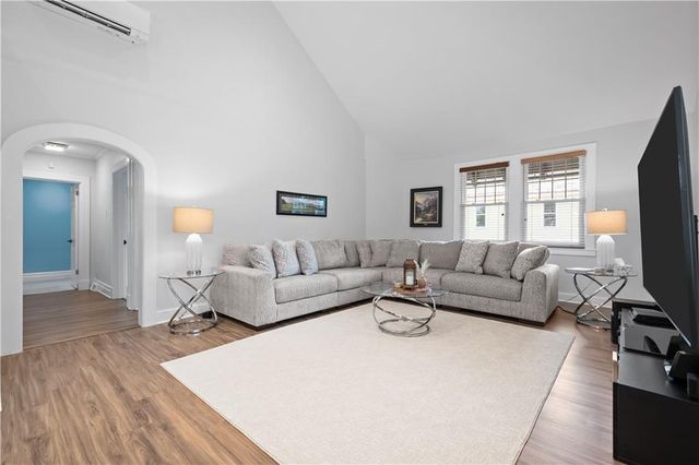 a living room with furniture a flat screen tv and a window