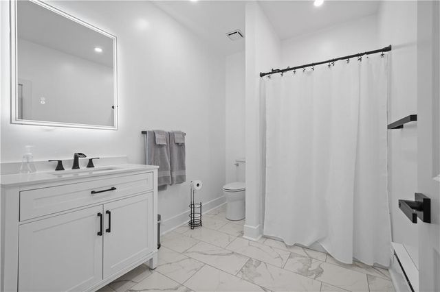 a bathroom with a sink toilet and shower