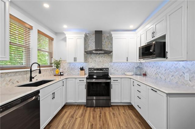 a kitchen with a sink stove top oven and cabinets