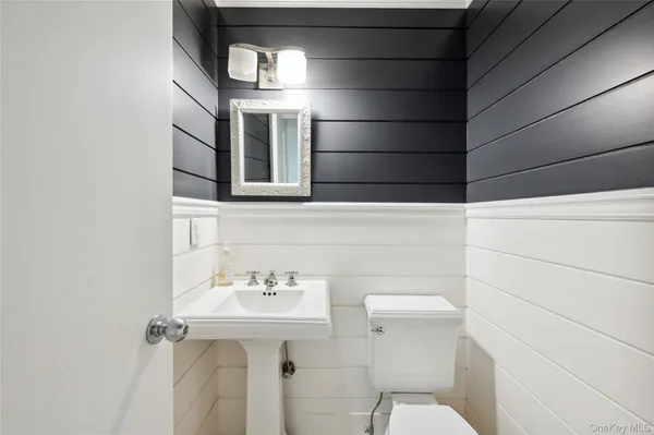 a bathroom with a sink a toilet and mirror