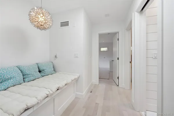 a living room with furniture flowerpot and a chandelier