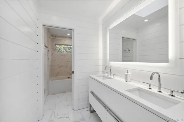 a bathroom with a double vanity sink mirror and shower