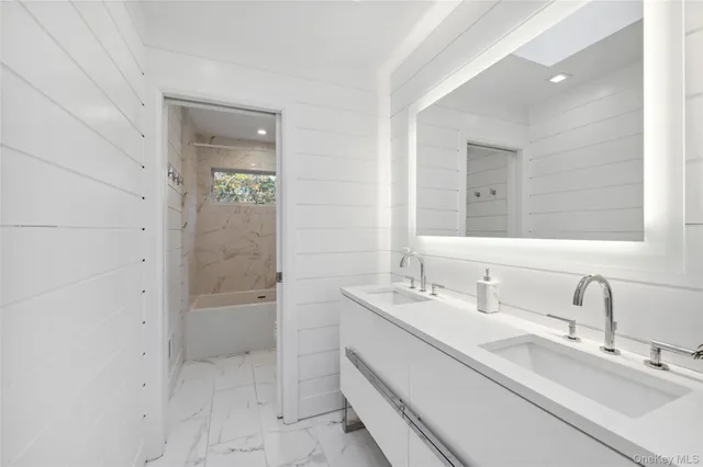 a bathroom with a double vanity sink mirror and shower