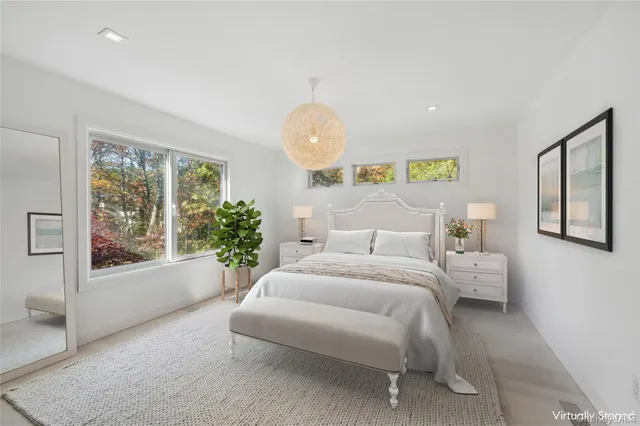 a spacious bedroom with a bed and a large window