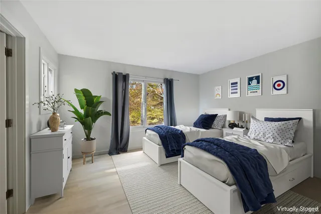 a bedroom with a two bed and a potted plant