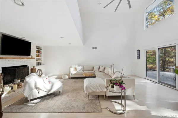 a living room with furniture a fireplace and a flat screen tv
