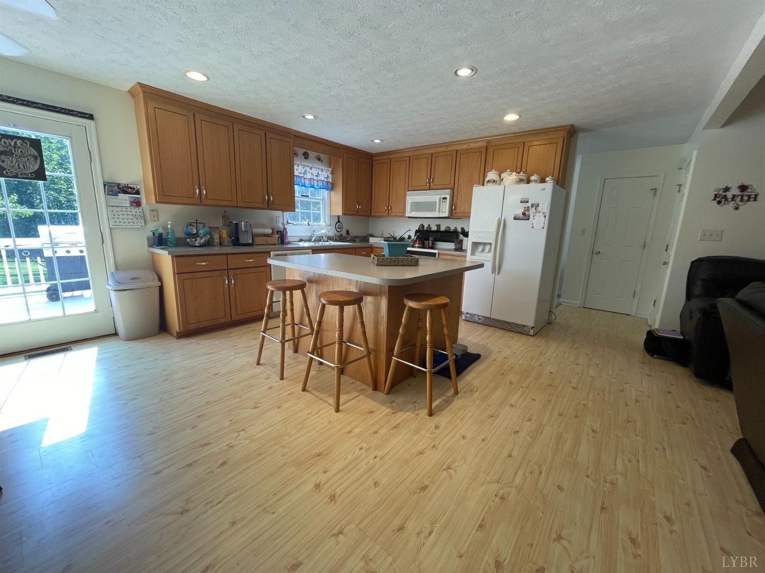 755 Bearfield Road Amherst, VA 24521 - Photo 33 of 98 a kitchen with stainless steel appliances granite countertop a refrigerator a sink a stove a dining table and chairs with wooden floor