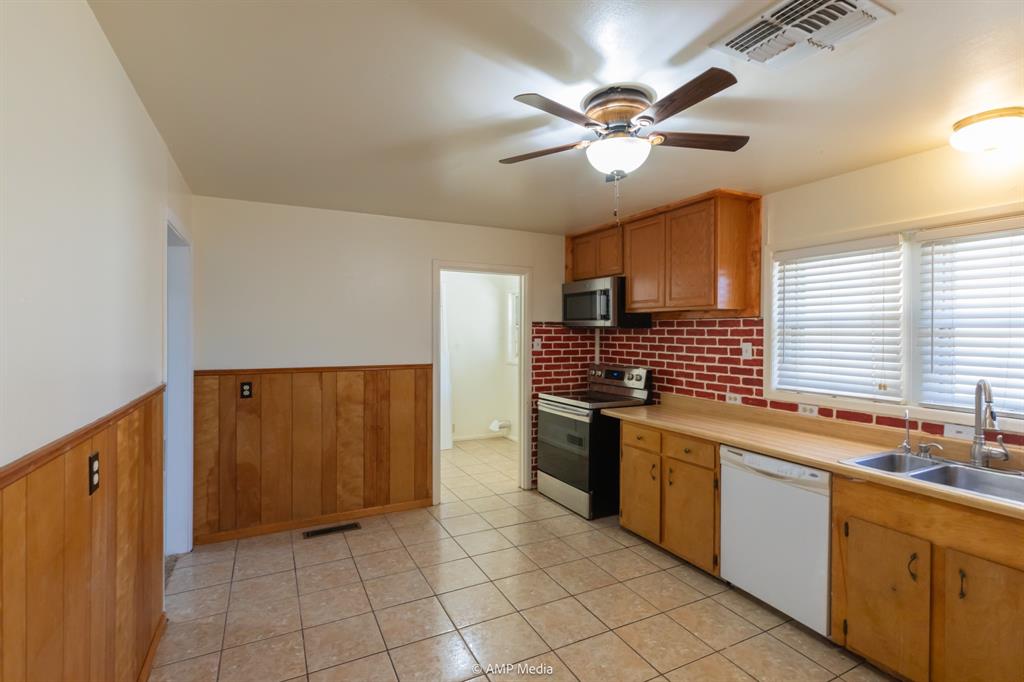 451 Northwest Ave F Hamlin, TX 79520 - Photo 11 of 29 a kitchen with stainless steel appliances sink cabinets and window