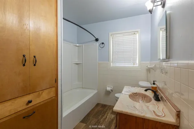 a bathroom with a tub shower and vanity