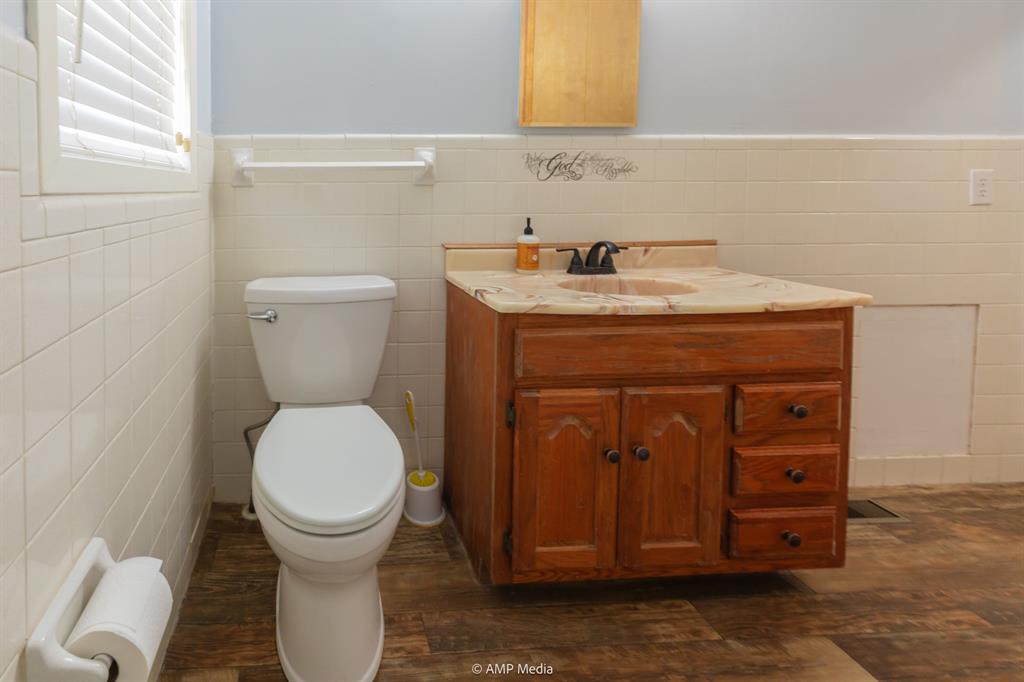 451 Northwest Ave F Hamlin, TX 79520 - Photo 14 of 29 a bathroom with a toilet and a sink