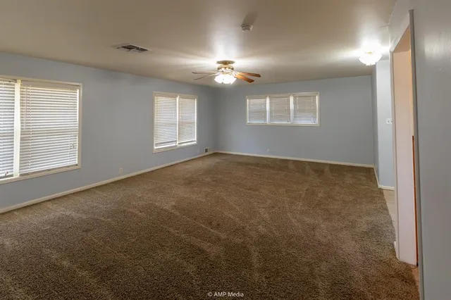 an empty room with closet and a chandelier fan
