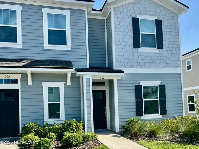 a view of a brick house with a large windows and plants
