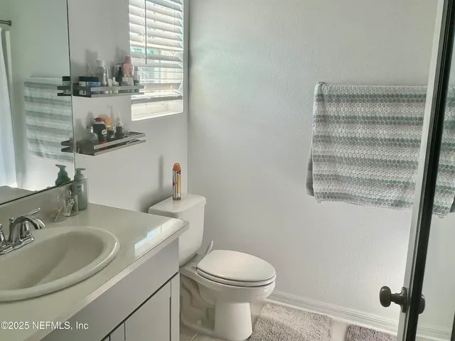 a bathroom with a sink a toilet and shower curtain