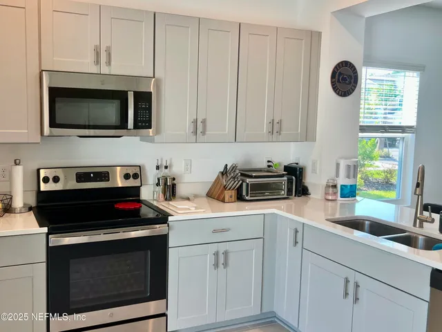a kitchen with white cabinets stainless steel appliances and sink