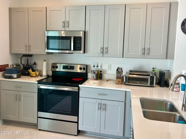 a kitchen with granite countertop white cabinets and white stainless steel appliances