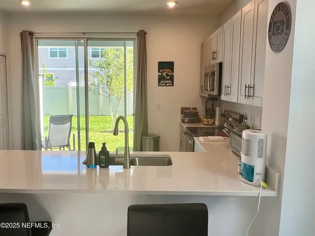 a kitchen with kitchen island a sink a stove and a window