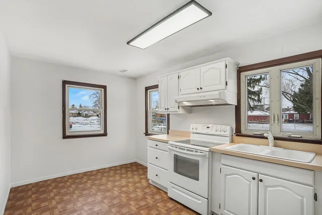 a kitchen with stainless steel appliances granite countertop a stove a sink and a granite counter tops with white cabinets