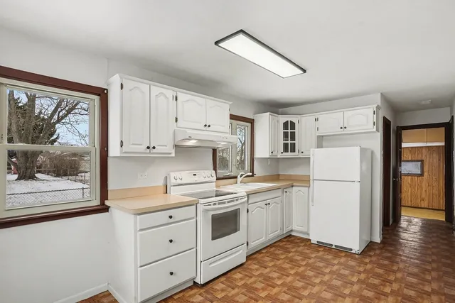 a kitchen with white cabinets and white appliances
