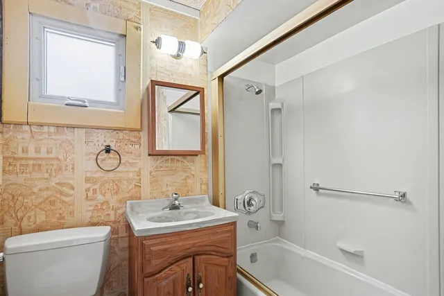 a bathroom with a sink toilet vanity and shower