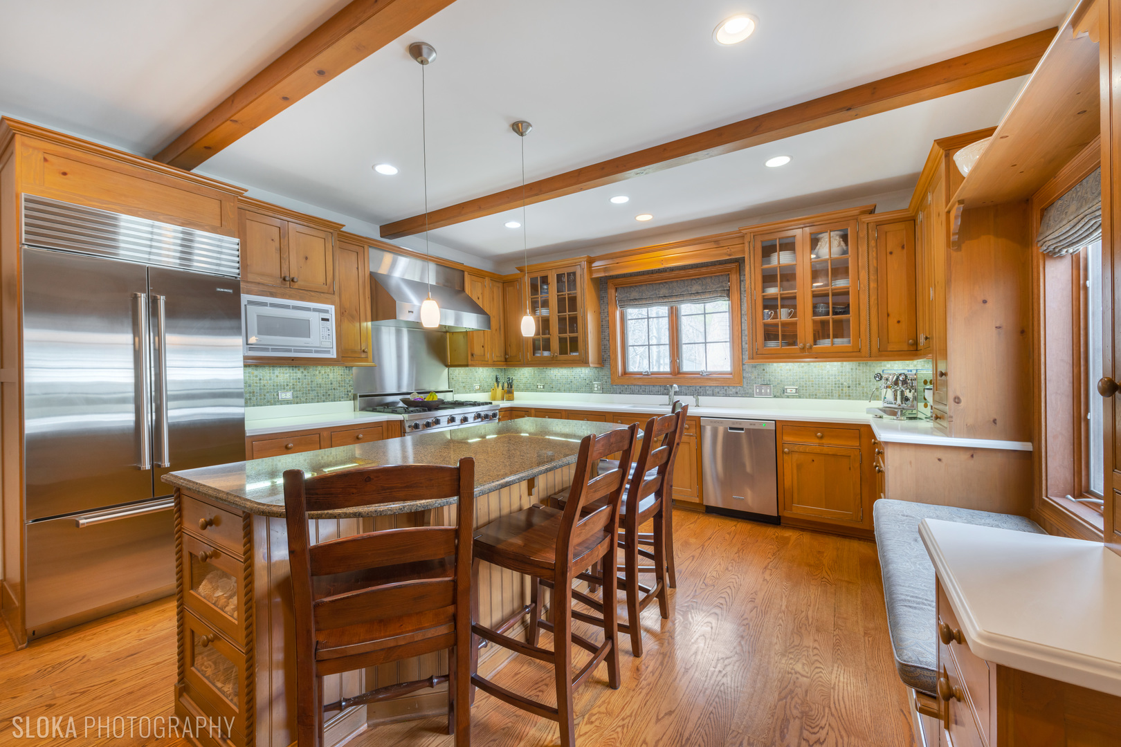 7812 East Tryon Grove Road Richmond, IL 60071 - Photo 8 of 55 a kitchen with stainless steel appliances granite countertop a kitchen island a stove a sink a refrigerator with a dining table and chairs