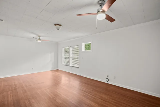wooden floor in an empty room with a window