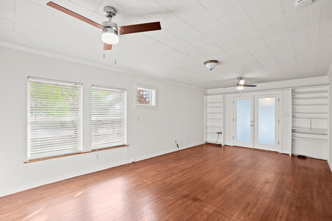 1707 Alguno Road, Unit C Austin, TX 78757 - Photo 12 of 16 featuring ceiling fan, french doors to sunroom, plenty of natural light, crown molding, and wood finished floors