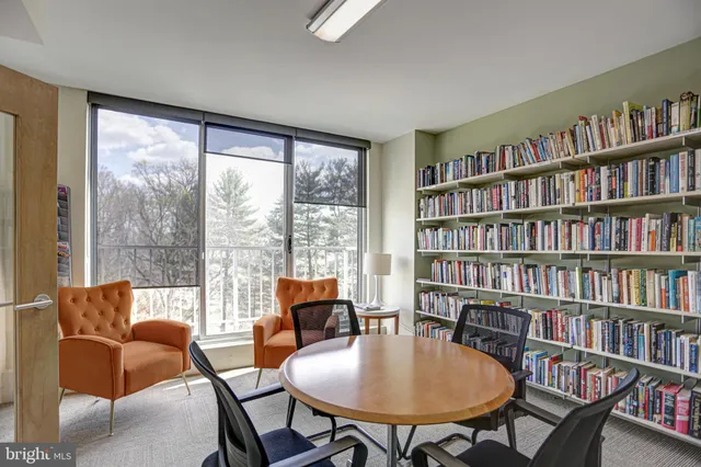 a living room with furniture and a book shelf