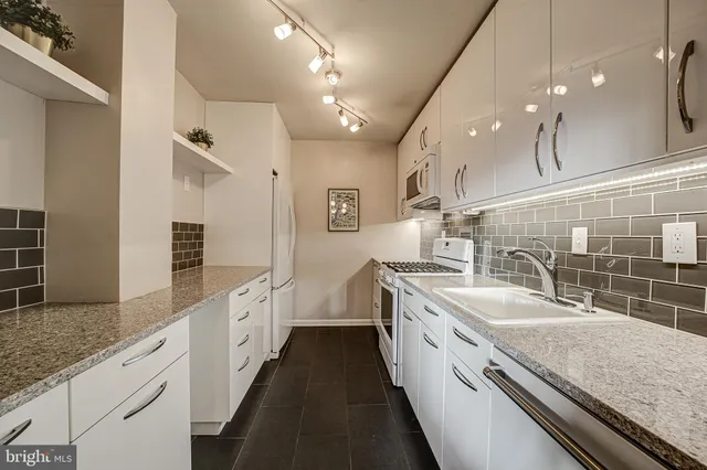 a large white kitchen with a large island