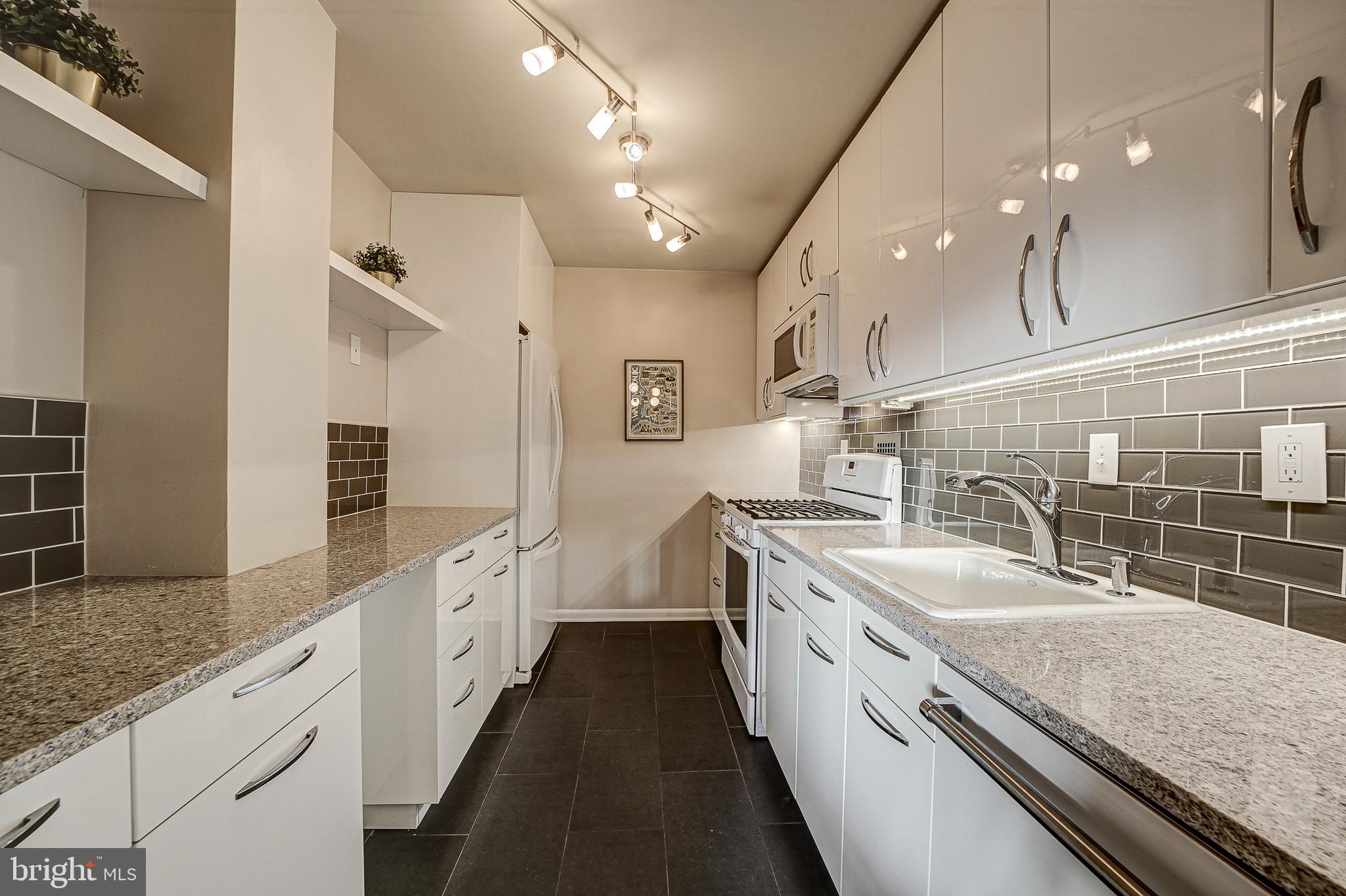 2939 Van Ness Street Northwest, Unit 1126 Washington, DC 20008 - Photo 9 of 31 a large white kitchen with a large island