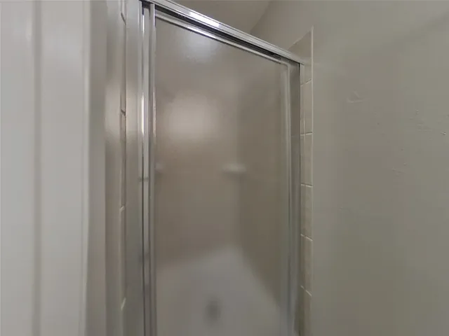a bathroom with a glass shower door