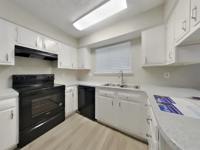 a kitchen with a sink stove and cabinets