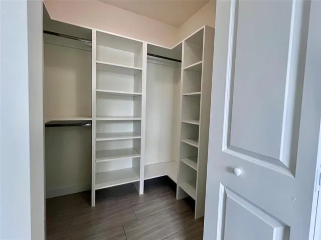 a view of walk in closet with empty racks
