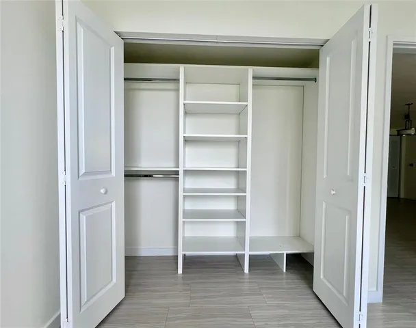 a view of walk in closet with empty racks