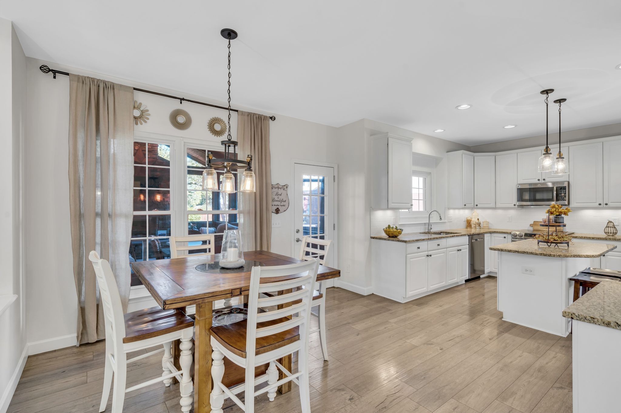 601 Rutherford Lane Franklin, TN 37064 - Photo 14 of 54 a kitchen with kitchen island a dining table chairs stove and white cabinets