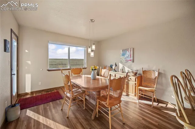 a view of a dining room with furniture a chandelier and wooden floor