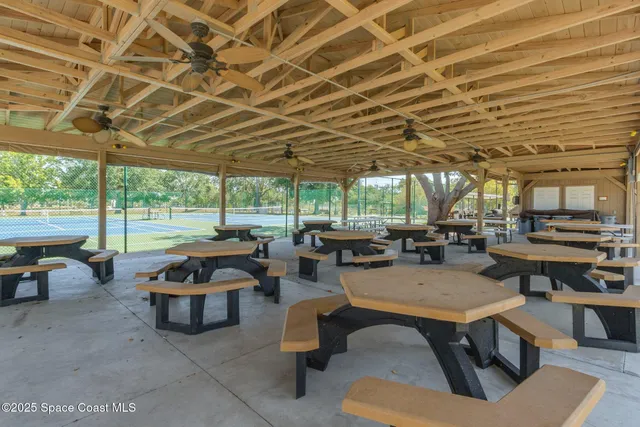 a outdoor space with lots of tables a chairs and a barbeque