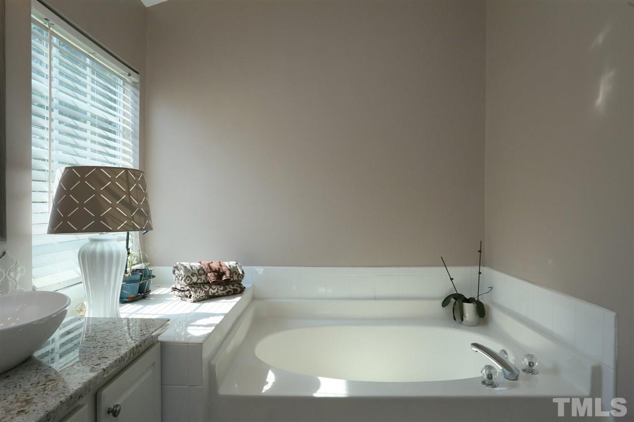 301 Burrell Road Durham, NC 27703 - Photo 15 of 30 a bathroom with a granite countertop sink and a bathtub