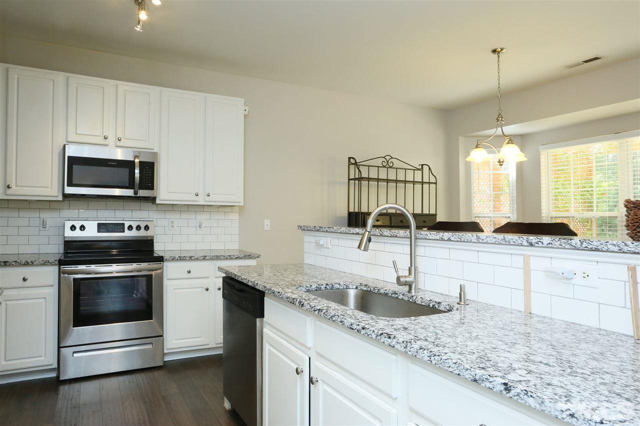 301 Burrell Road Durham, NC 27703 - Photo 8 of 30 a kitchen with stainless steel appliances granite countertop a sink and stove top oven
