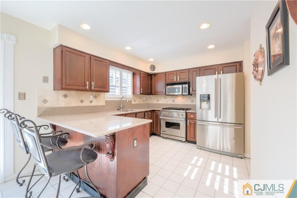 3 Old Road Monroe Township, NJ 08831 - Photo 9 of 25 a kitchen with stainless steel appliances granite countertop a refrigerator sink and stove