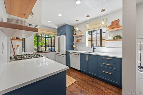 a large kitchen with stainless steel appliances a large counter top a stove and a refrigerator