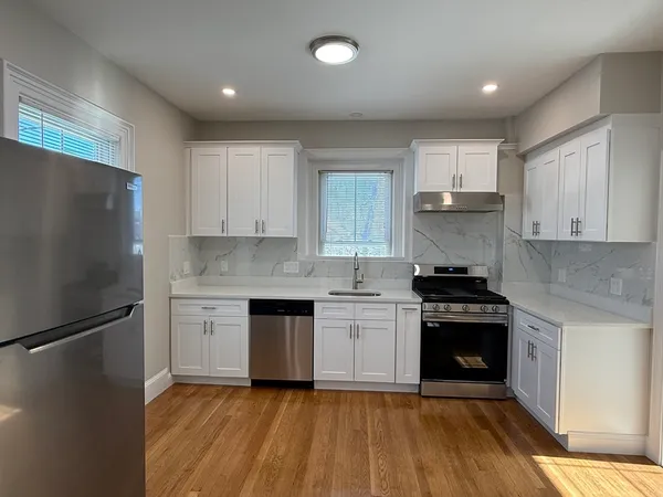 a kitchen with granite countertop a refrigerator stove and sink
