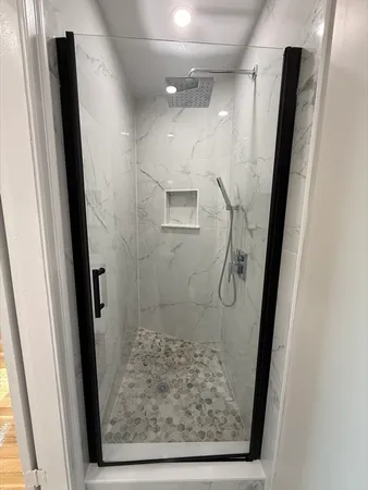 a bathroom with a glass door shower and a sink