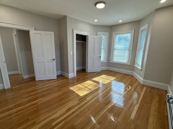 a view of a livingroom with wooden floor and bathroom