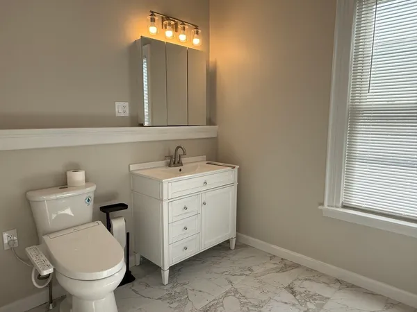 a bathroom with a toilet sink and mirror